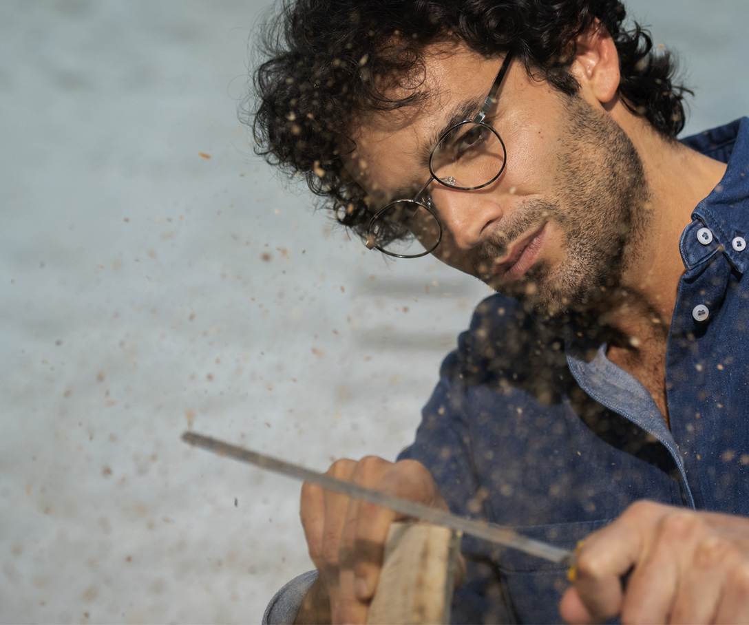 man in glasses doing woodworking